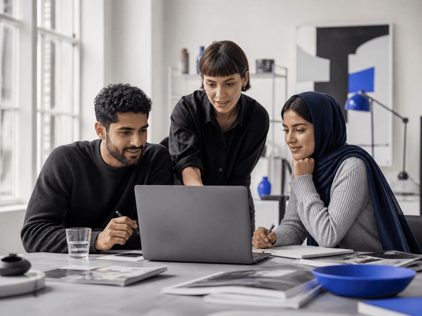 Independent professionals collaborating around a laptop